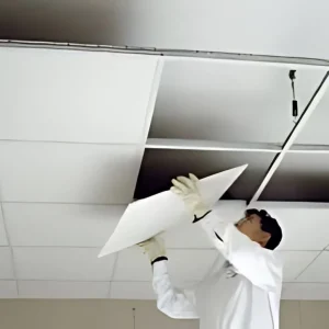A man is installing Gypsum False Ceiling Tiles